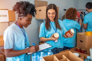 Volunteers Marking And Packing Jars Into Boxes