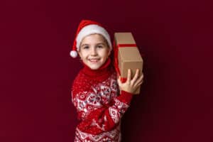 Girl Holding Holiday Gift With Holiday Clothing