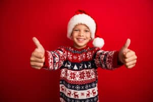 Child With Christmas Clothing With A Red Background