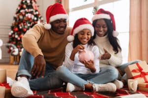 Familly Putting Money In A Piggy Bank During Christmas